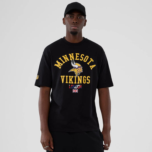 The Male model is wearing Minnesota Vikings NFL International Series Games 2025 Black Oversized T-Shirt 1