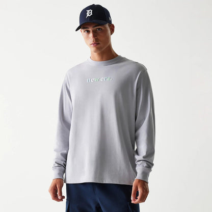 The Male model is wearing New Era 90s Vibe Grey Long Sleeve T-Shirt 1
