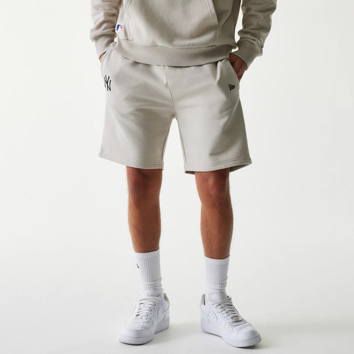 The Male model is wearing New York Yankees MLB League Essential Midi Cream Shorts 1