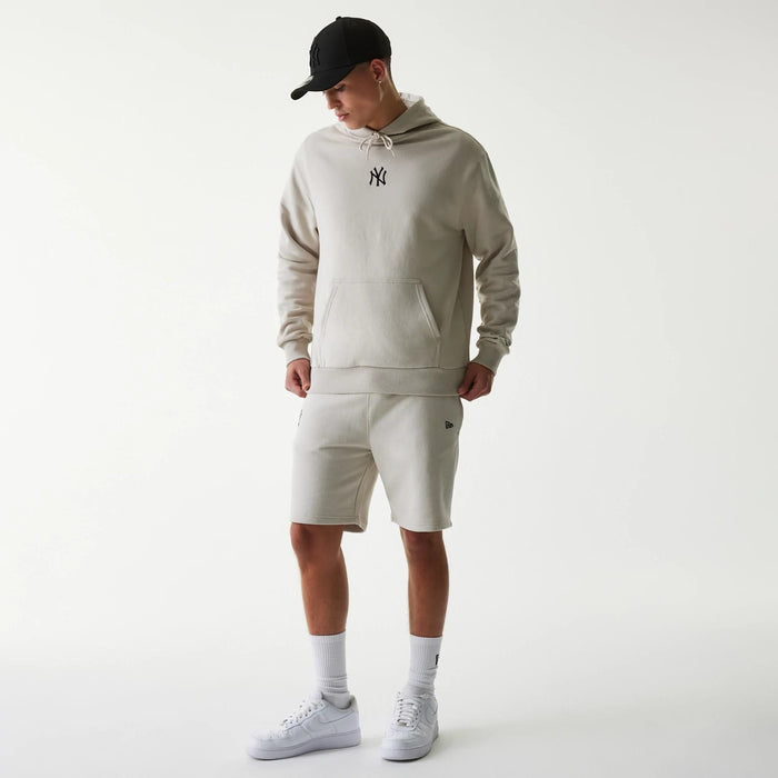 The Male model is wearing New York Yankees MLB League Essential Midi Cream Shorts 8